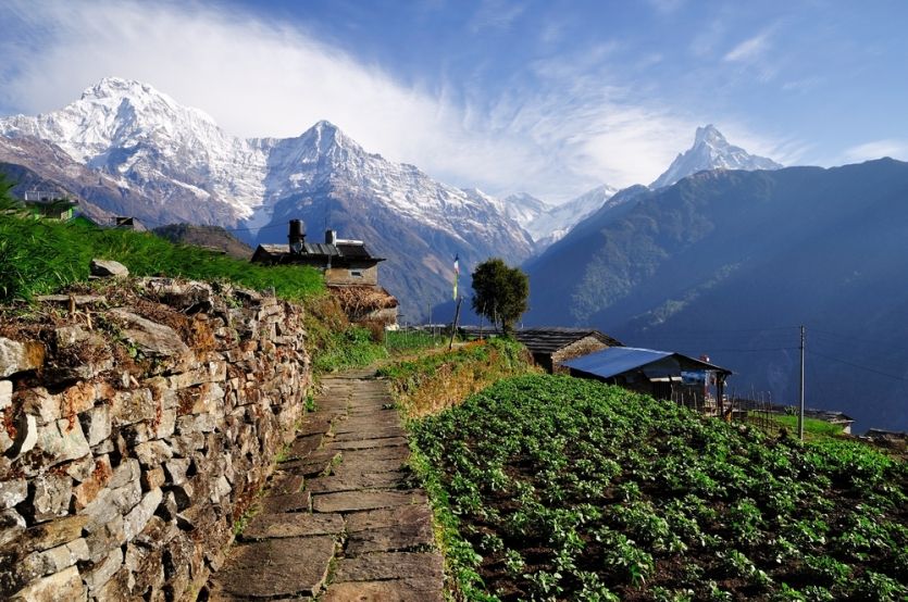 Hiking through a village with a view of snow-capped mountains in the Annapurna Region in Nepal