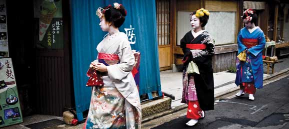 Geishas walking into a building in Japan